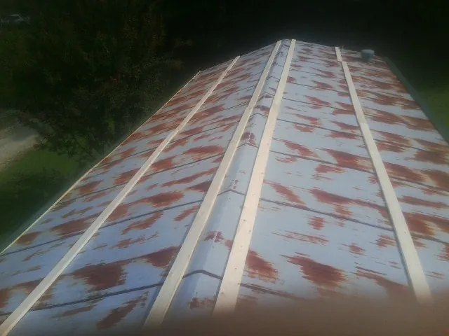 Rusted metal roof panels with new wood purlins before replacement — Storm Damage Roof Repair in South Pittsburg by Roofing Brothers