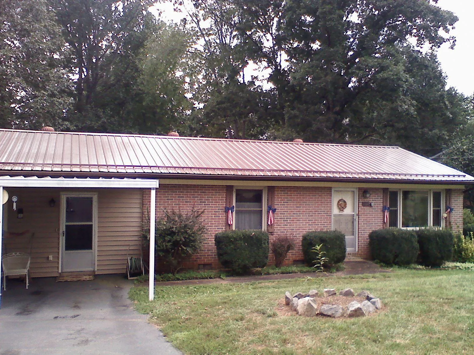 Bronze metal roof and carport on a brick ranch home — Roof Repair work by our crew in South Pittsburg